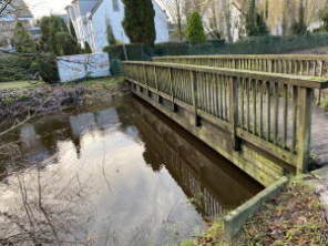 Rotbachwasserspiegel wenige Zentimeter unter einer Holzbrücke